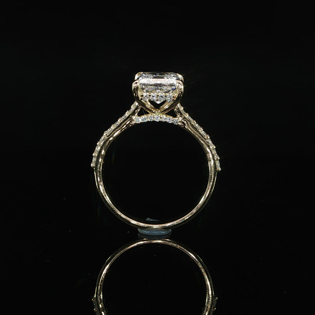 Side view of a princess cut engagement ring highlighting the hidden diamond halo beneath the center stone.