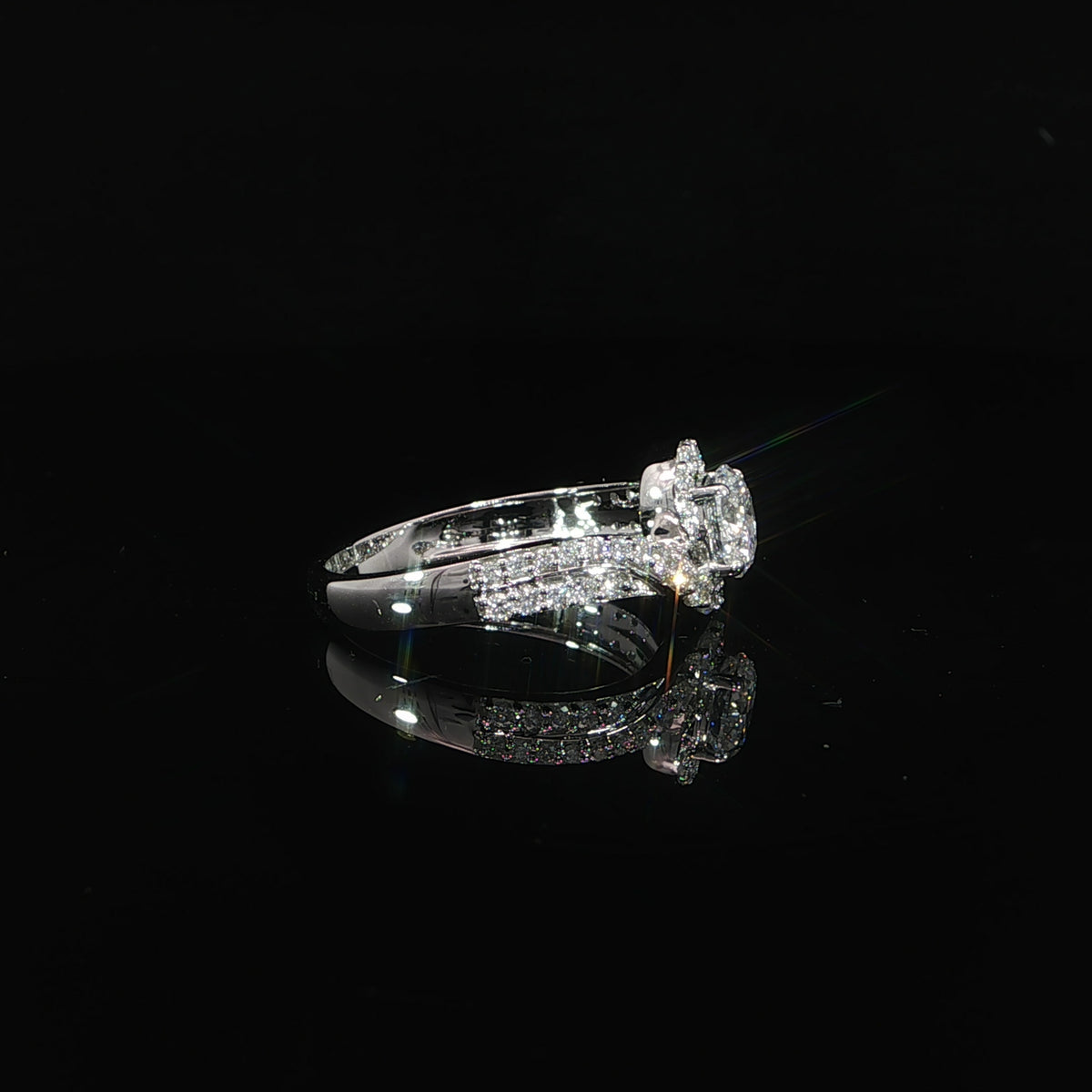Side profile of a round bypass diamond ring showing the raised center setting and pavé shoulders.
