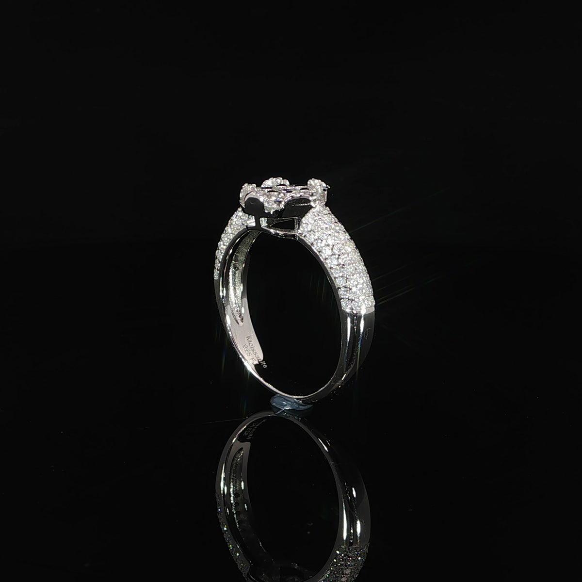 Side profile of a sterling silver ring showing its elevated cluster and curved pavé shoulders.