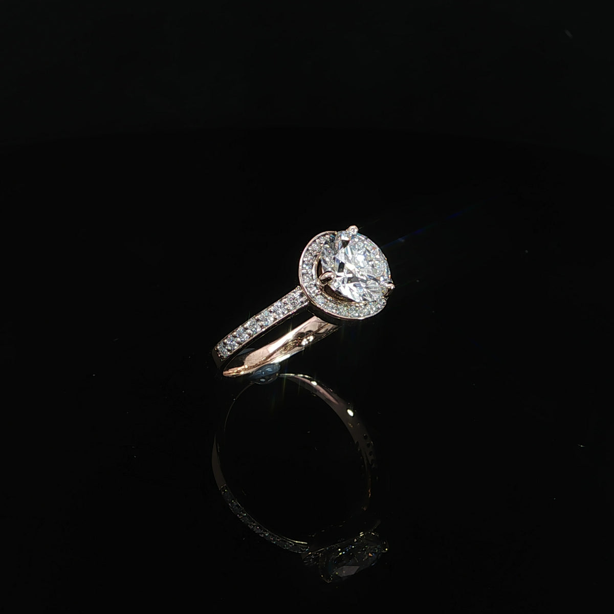 Front view of a round diamond bypass engagement ring in 14K rose gold with curved pavé diamond bands.
