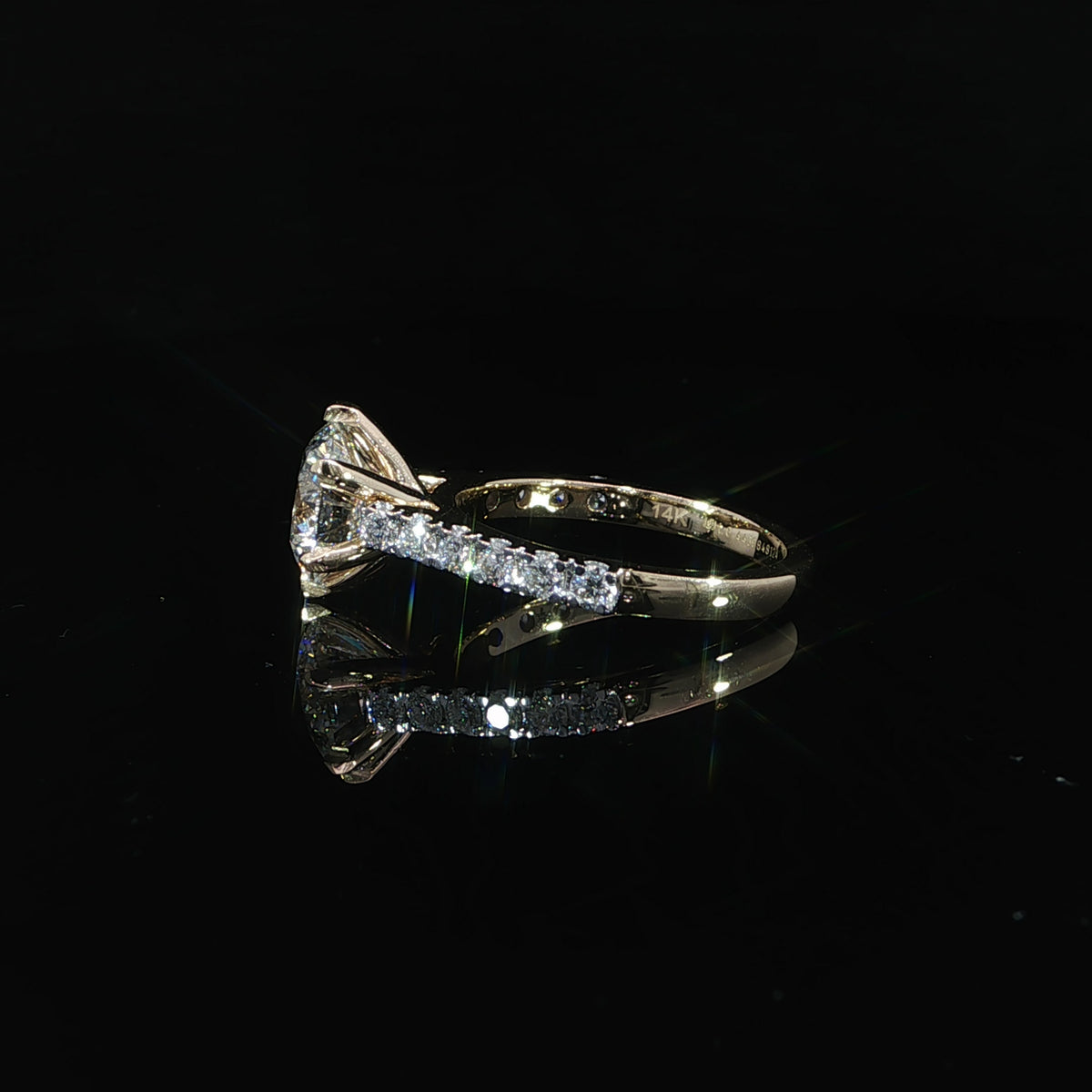 Side view of a round diamond cathedral ring showing the elevated center stone and diamond-set shoulders.