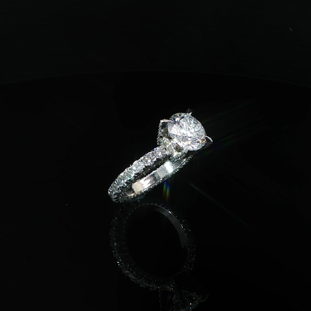 Standing three-quarter view of a white gold round diamond ring with a diamond eternity band