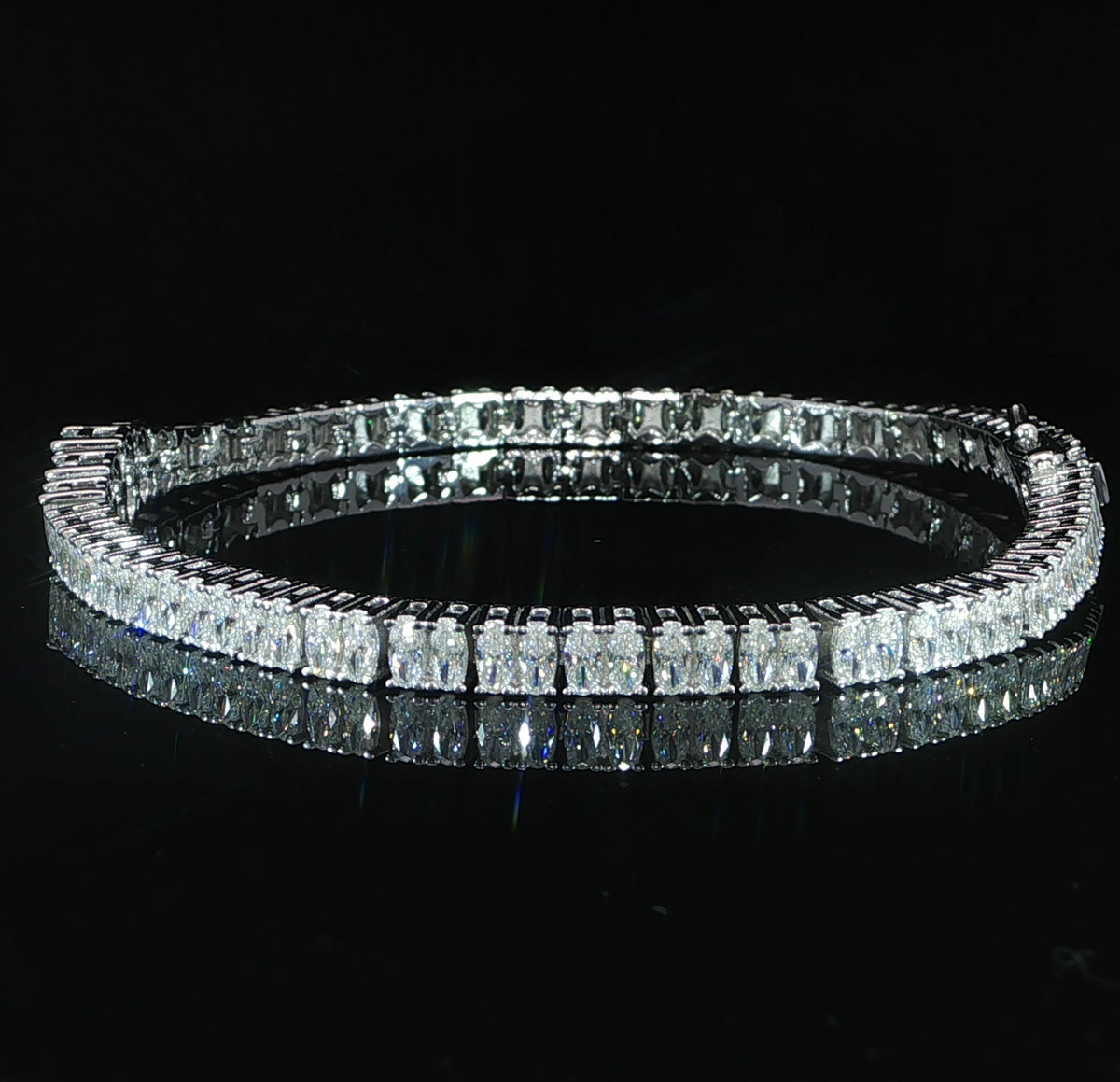 Side view of an oval-cut moissanite tennis bracelet in sterling silver