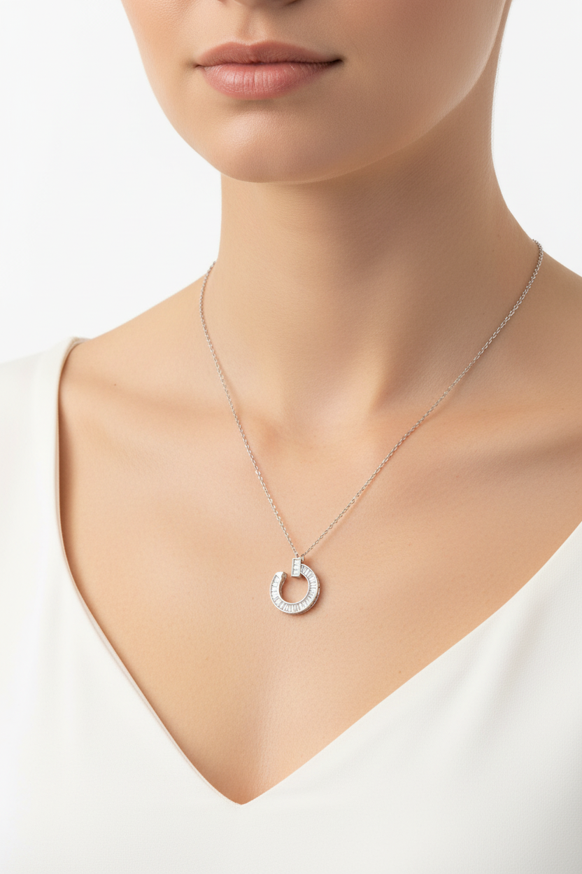 Sterling silver curved nail pendant necklace featuring 0.95 CTW moissanite in a channel setting with baguettes.