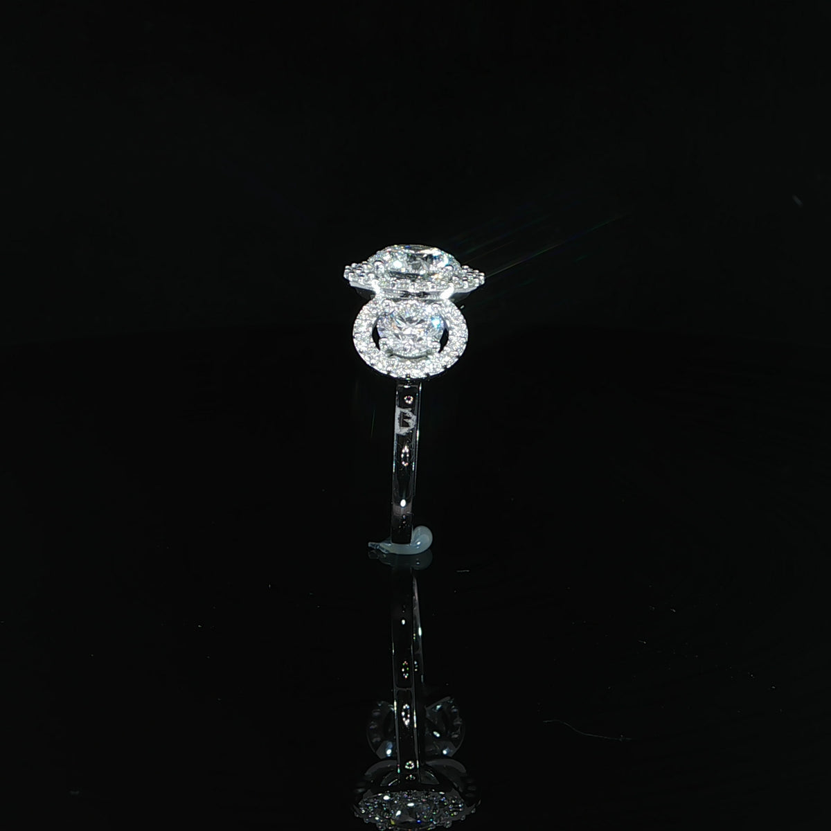 Detail of a side diamond and its surrounding halo in 14K white gold.