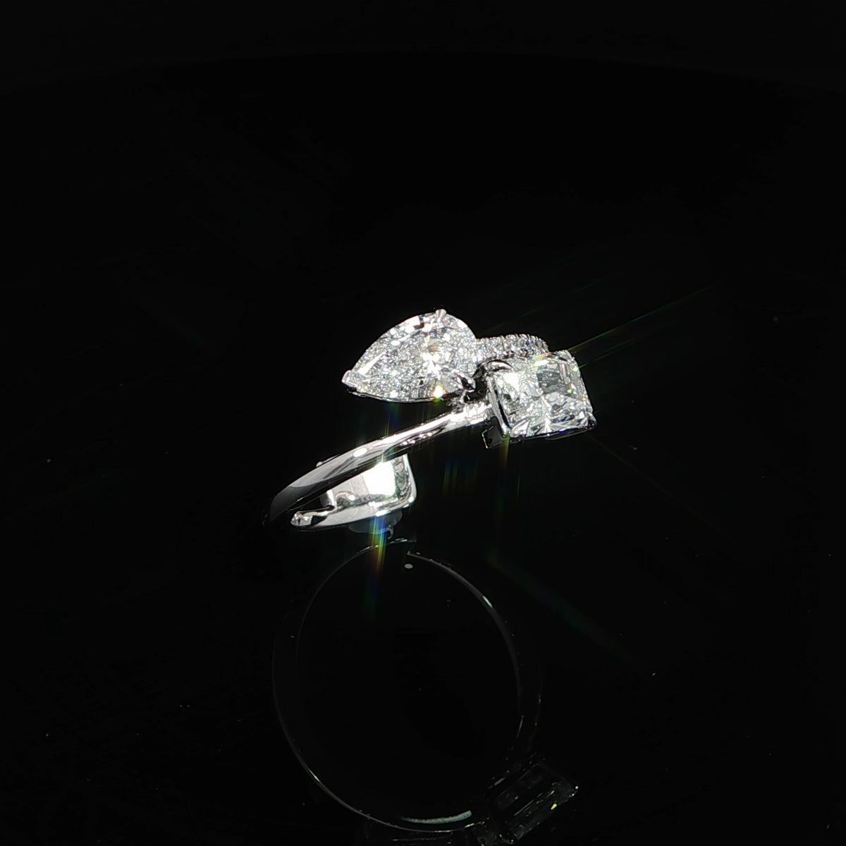 Asymmetrical Toi et Moi ring with radiant and pear shaped lab grown diamonds in a modern two-stone setting.