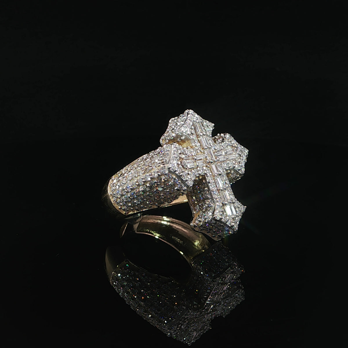 Side profile of a diamond cross ring showing its raised face and wide yellow gold shank.