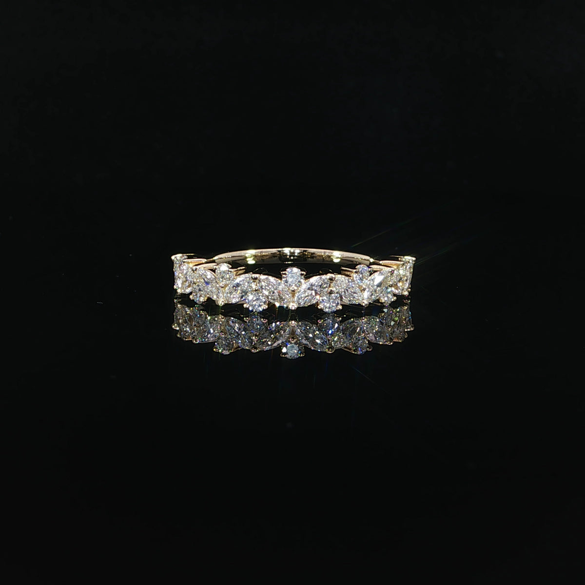 Front view of a yellow gold band featuring angled marquise diamonds and round diamond accents.