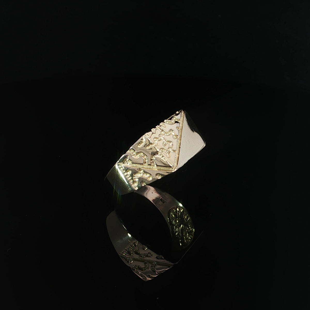 Angled view of a yellow gold nugget ring showing raised irregular patterns extending onto the shoulders.