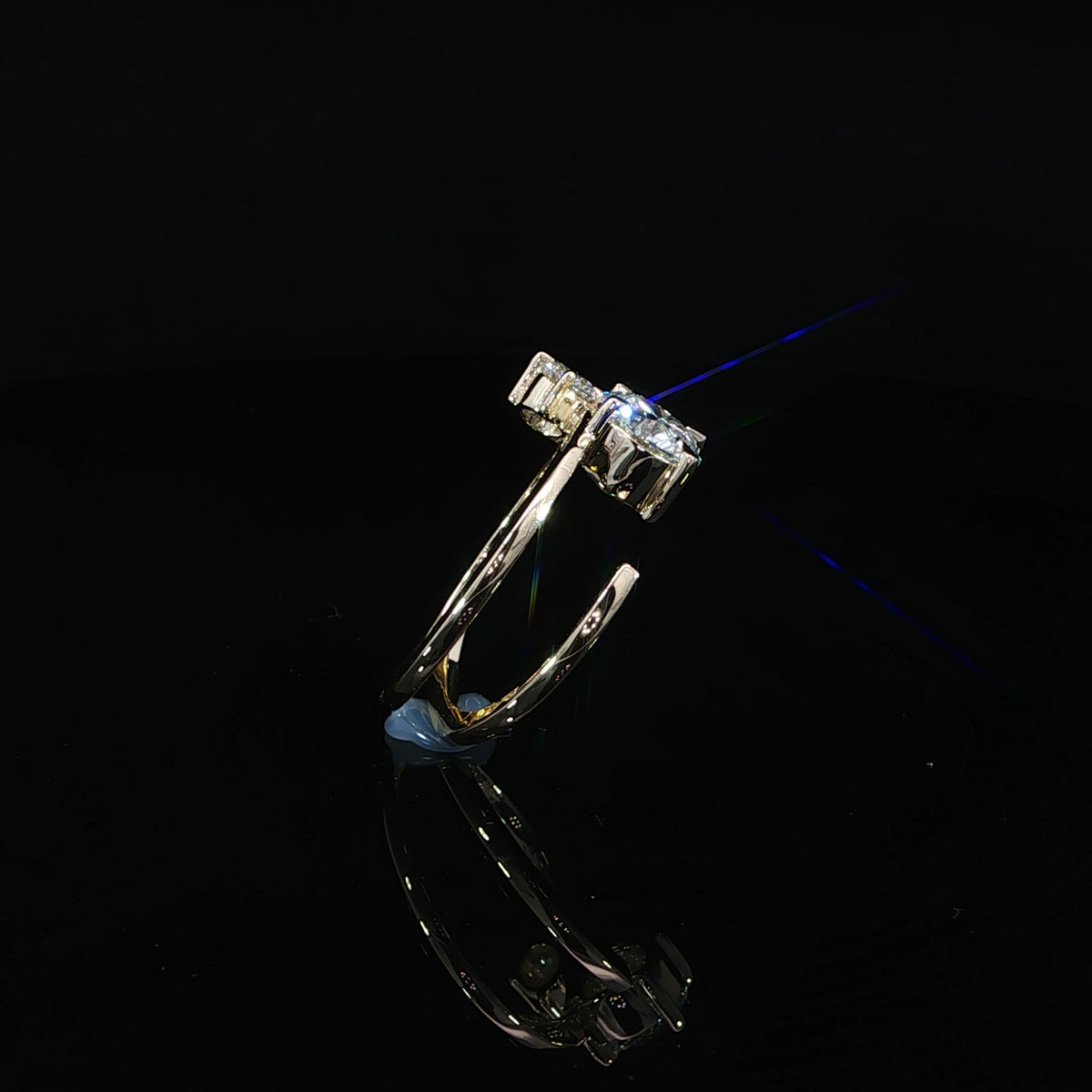 Angled side view of two round diamonds in prong settings above a curved yellow gold band.