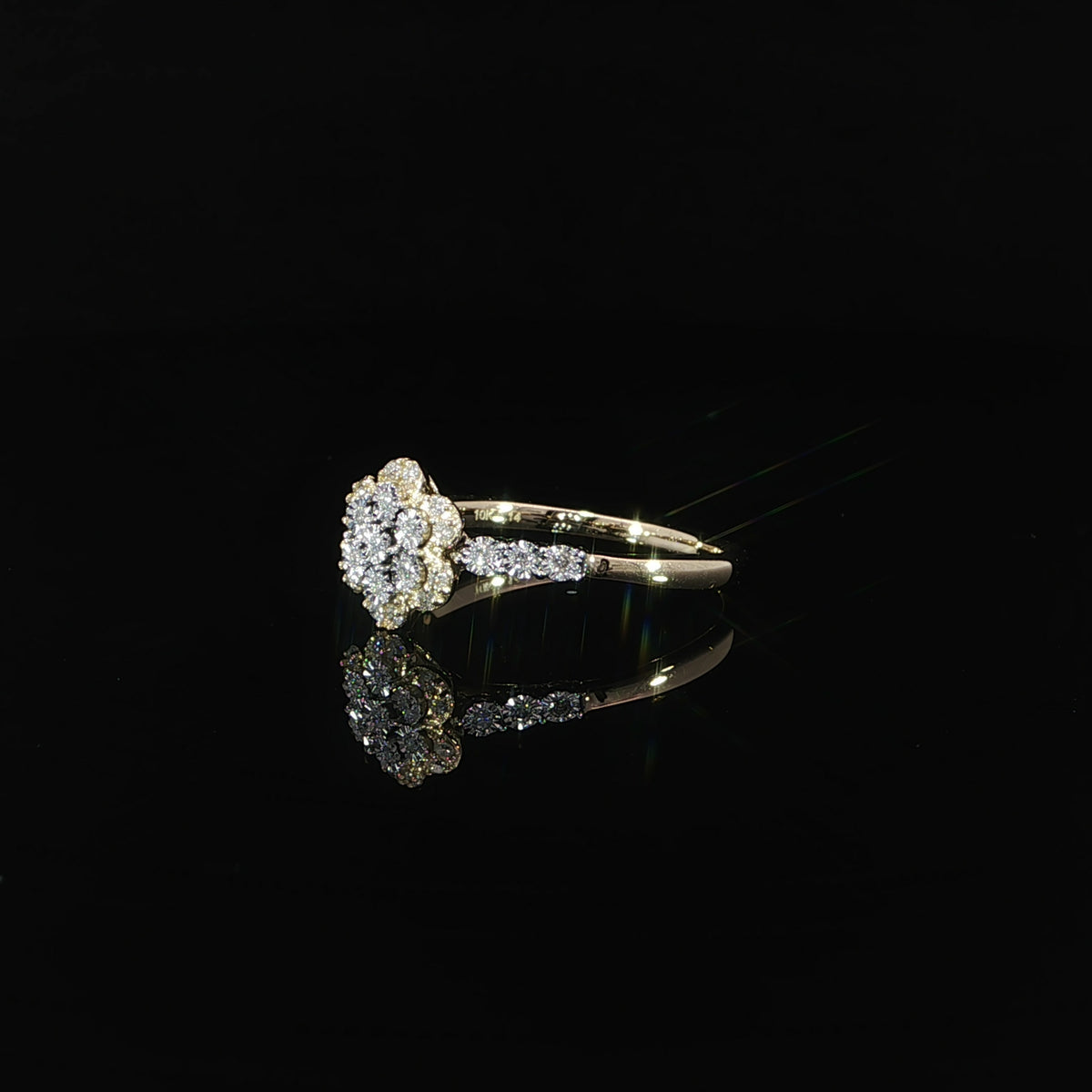 10K yellow gold 0.14 CTW flower promise ring resting on a reflective black surface.