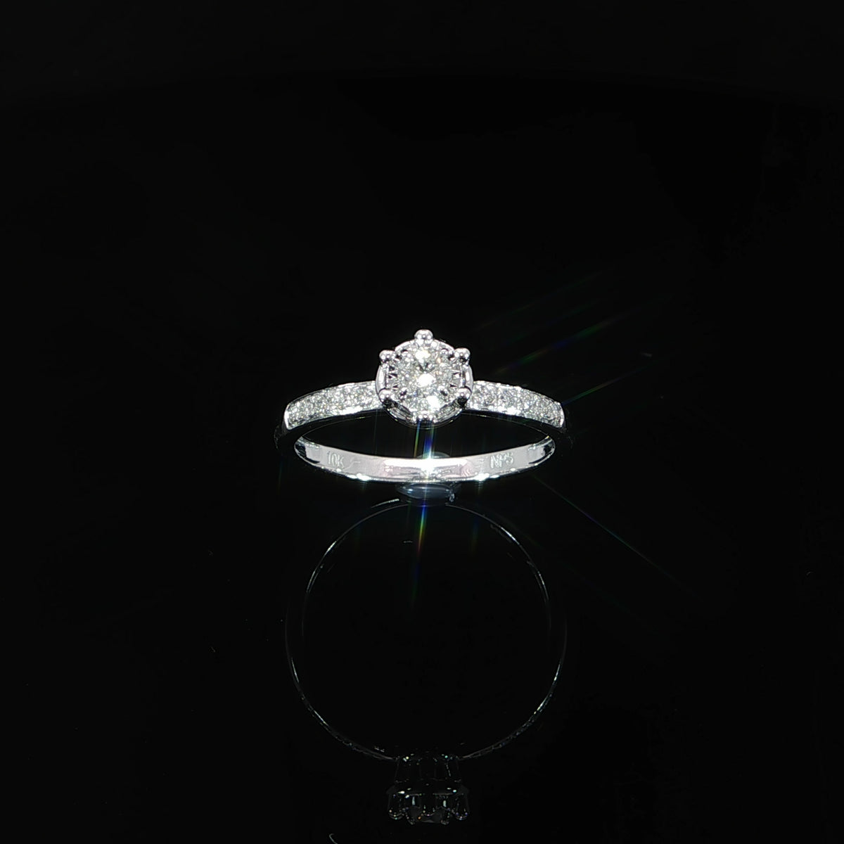 Face-on view of a 0.22 CTW natural diamond illusion ring in 10K white gold, showing both diamond-set shoulders.