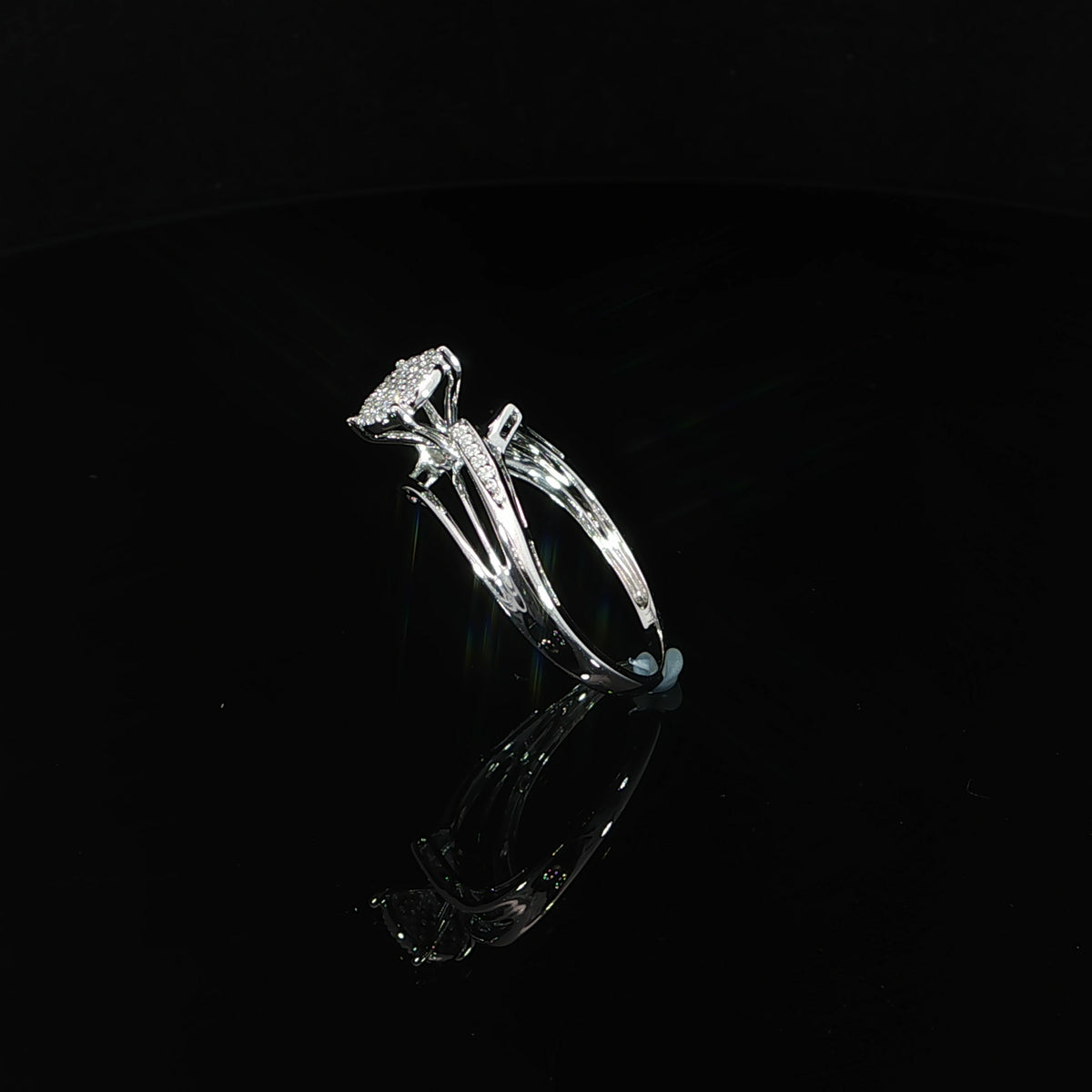 Tilted view of a 10K gold 0.07 CTW diamond composite ring showing elongated openings in the shoulders.
