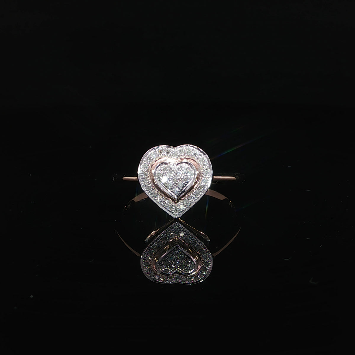 Resting front view of a 10K rose gold 0.10 CTW double heart ring with a diamond cluster inside a heart outline.