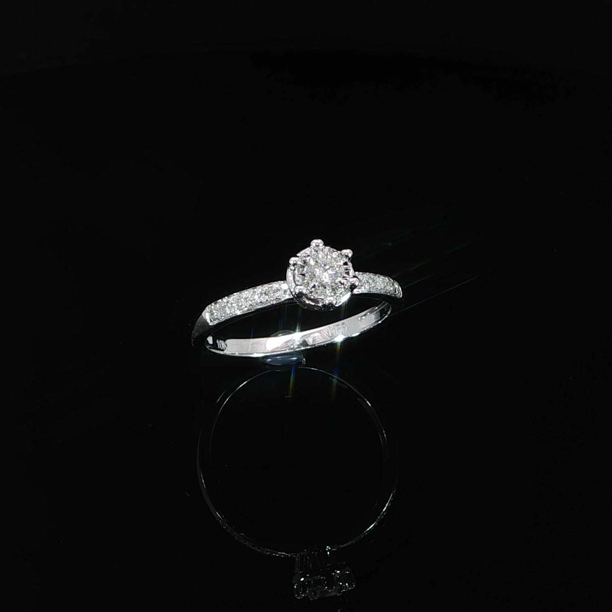 Angled front view of a 10K white gold 0.22 CTW diamond illusion ring showing the round setting and shoulder diamonds.