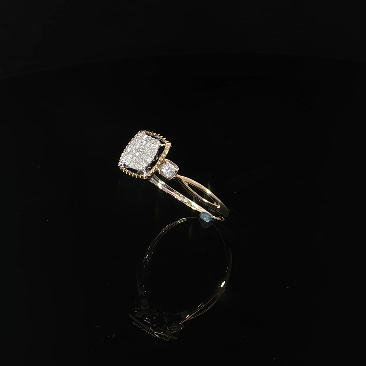 Diagonal view of a 10K yellow gold cushion cluster ring, showing its raised head and open shoulder design.