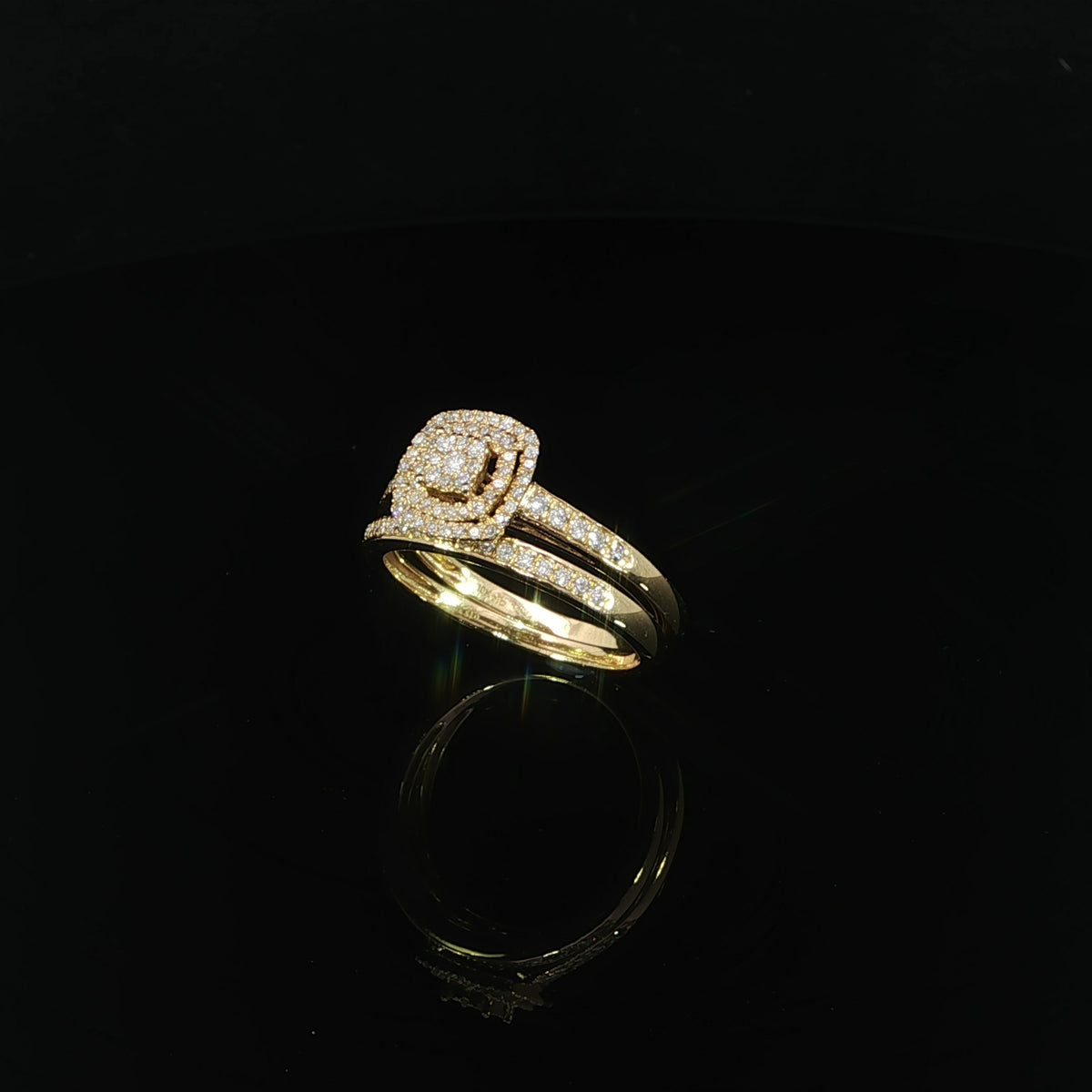 Diagonal side view of a 10K yellow gold wedding set, showing two diamond-accented bands and a raised cluster setting.
