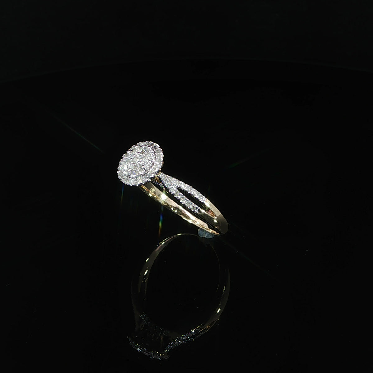 Three-quarter view of a 10K yellow gold 0.40 CTW diamond cluster ring with a halo and split shank.