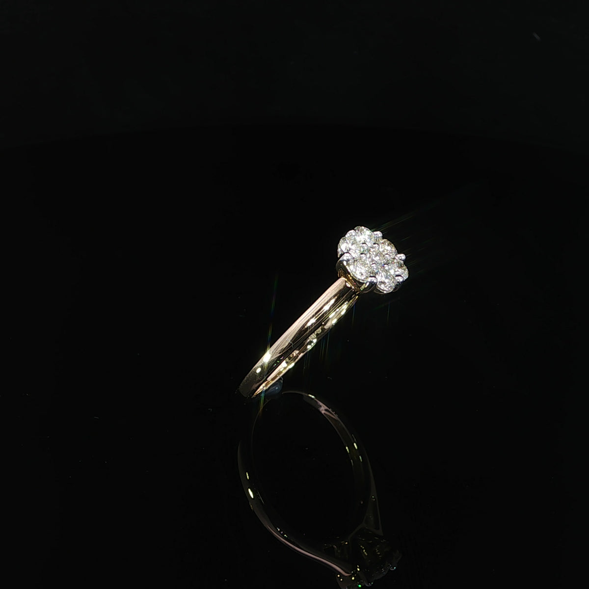 A 10K yellow gold 0.50 CTW diamond ring viewed from an angle, with a floral cluster above tapered gold shoulders.