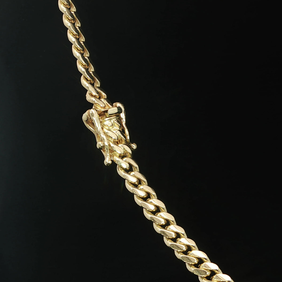 Close-up of the box clasp and safety catches on a 10K yellow gold Miami Cuban necklace