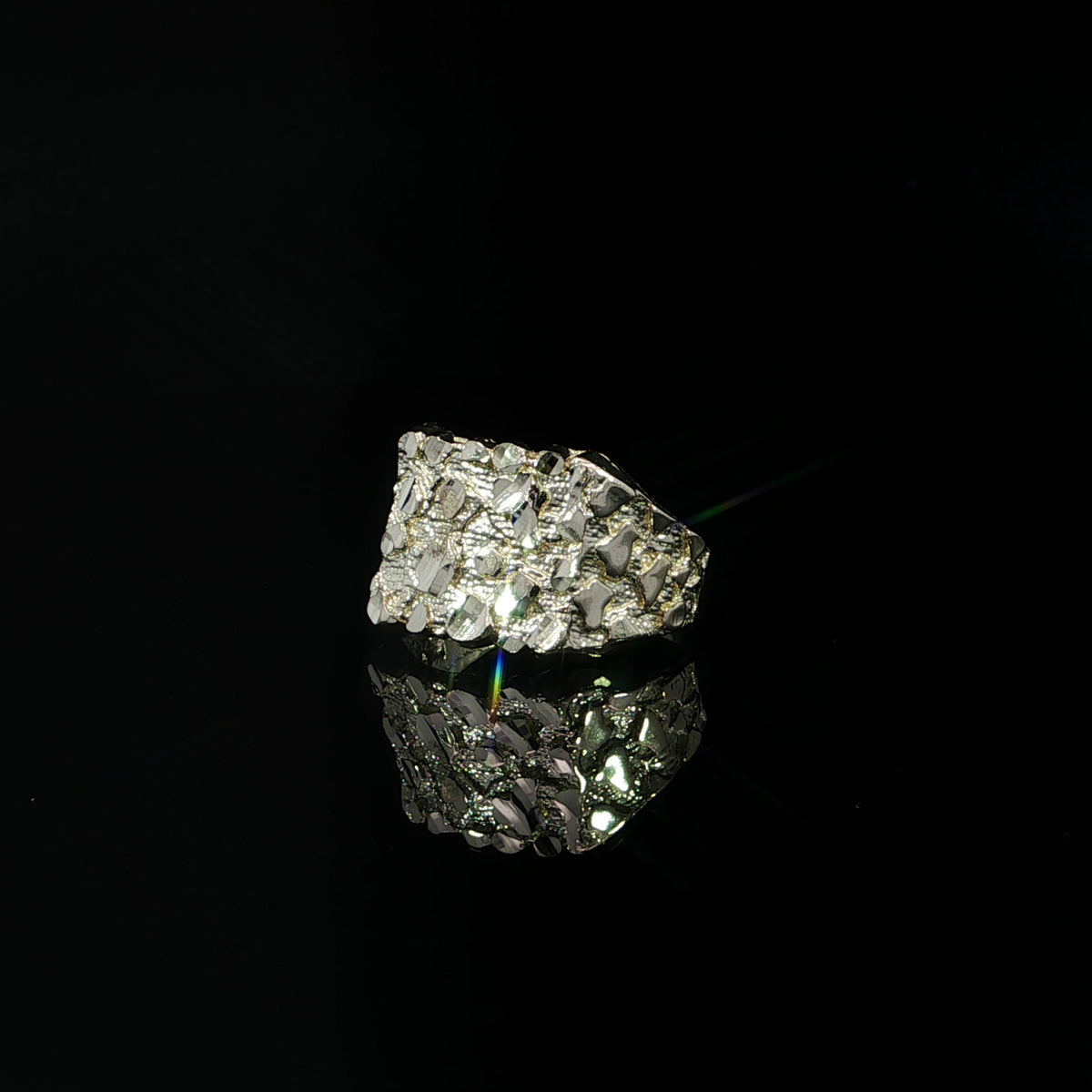 Side view of a yellow gold nugget ring showing its textured shoulders tapering into a polished band.