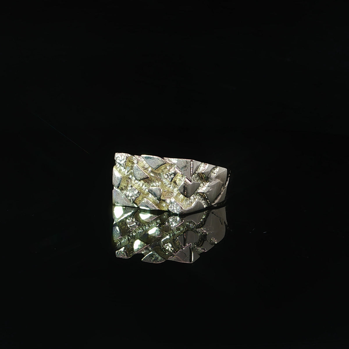 Irregular polished gold shapes and recessed texture across the face of a 10K yellow gold nugget ring.