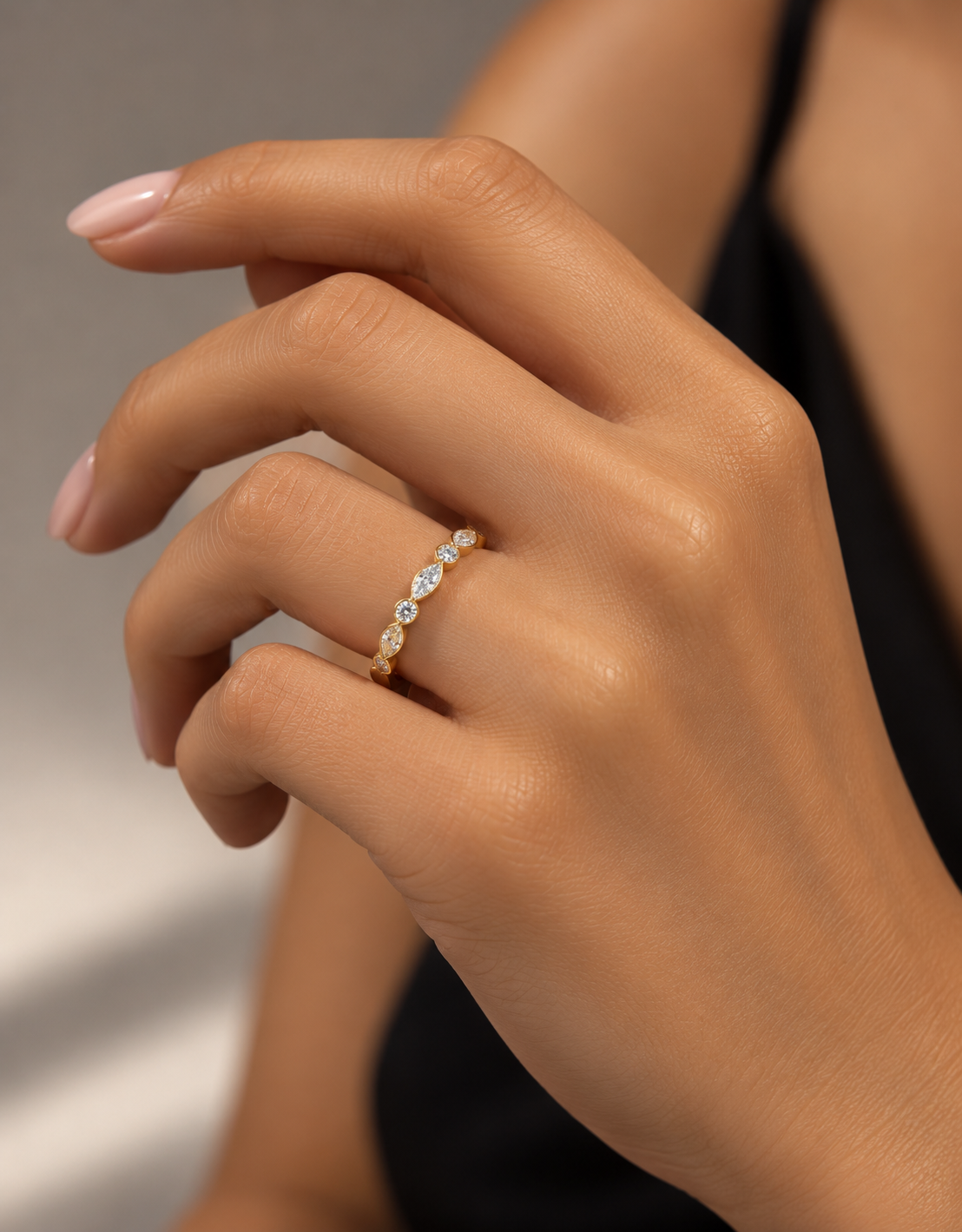Model wearing yellow gold wedding band with 0.41 CTW marquise and round lab grown diamonds secured in polished bezel settings.