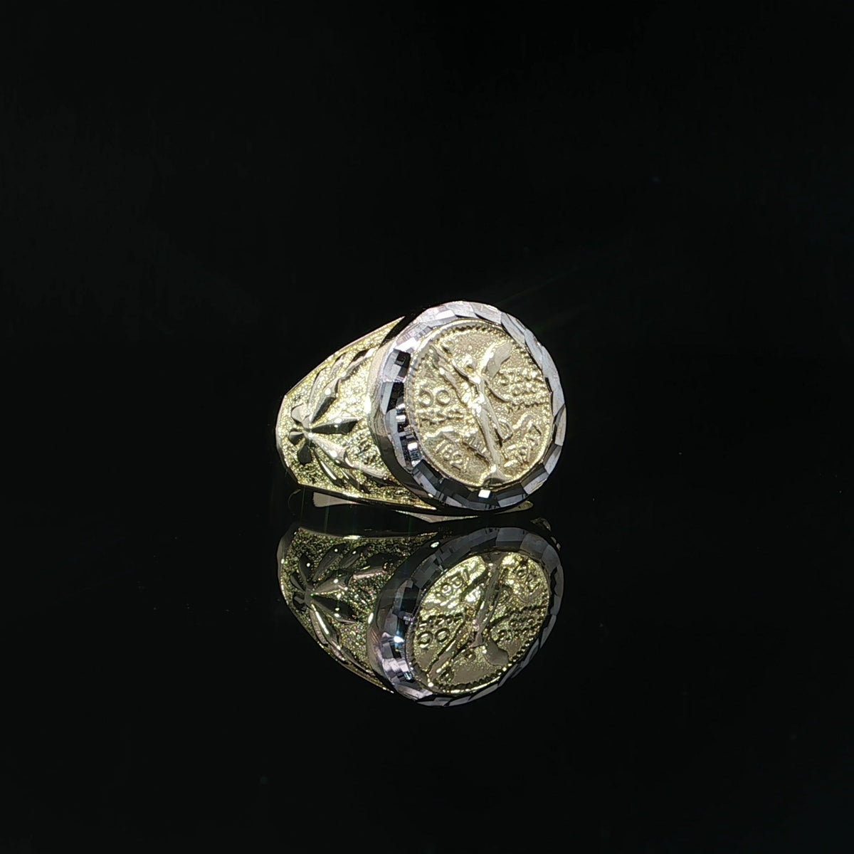Front view of a 14K yellow gold Centenario-inspired signet ring with a winged figure and faceted white accent border.
