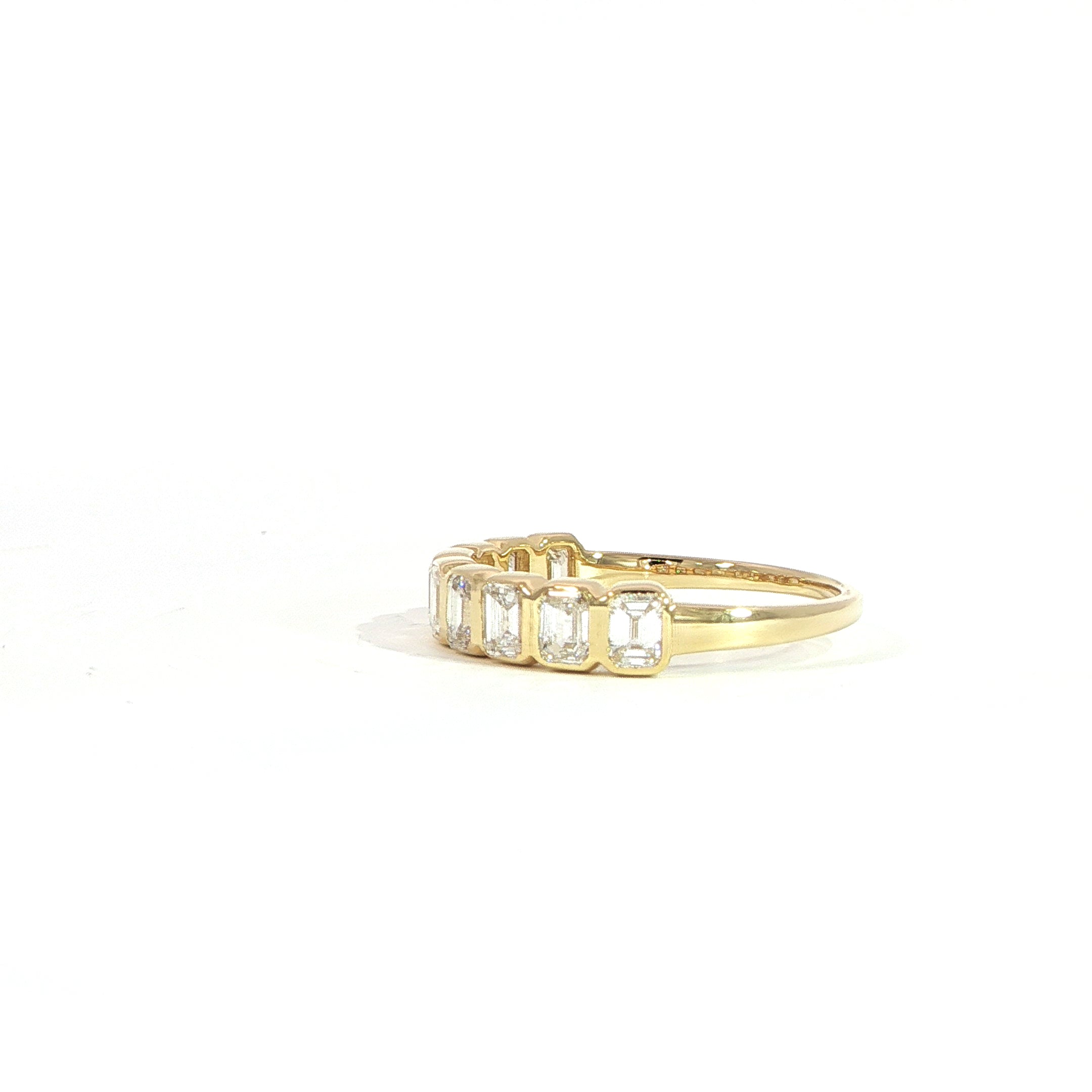 Side view of 14K gold emerald cut diamond band