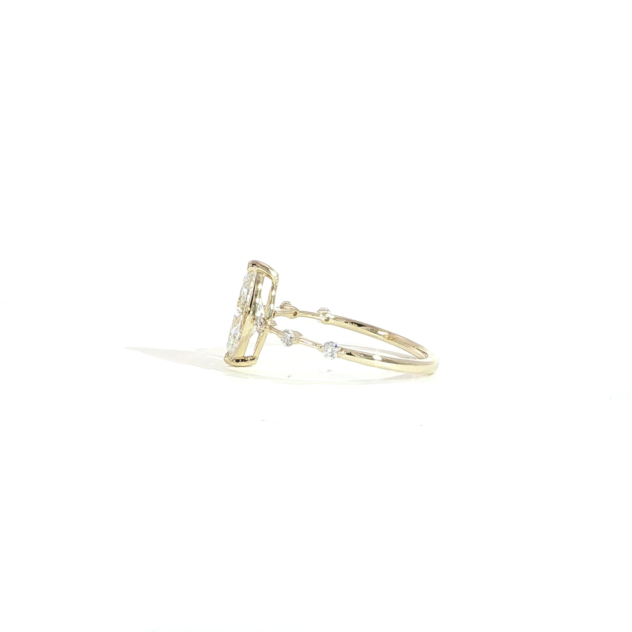 Side view of marquise solitaire ring with station diamonds