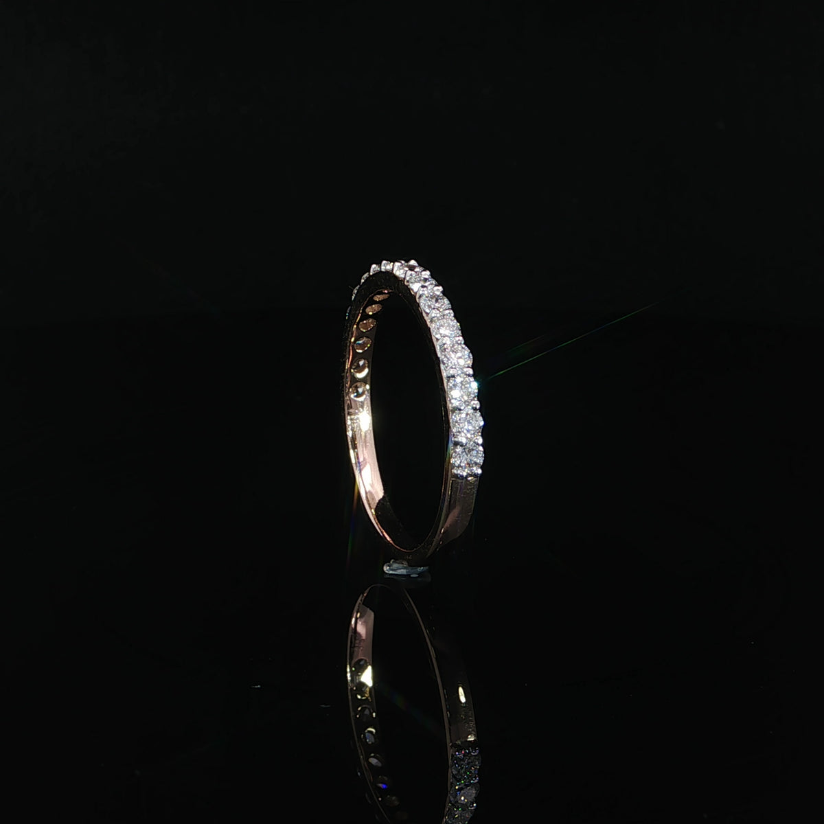 Upright side profile of a 14K rose gold diamond band with a smooth lower shank.