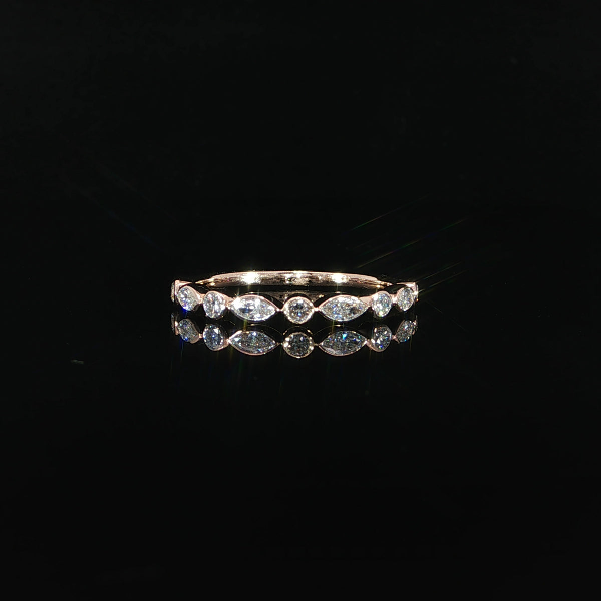 14K rose gold band featuring alternating marquise and round bezel set lab grown diamonds totaling 0.41 CTW.