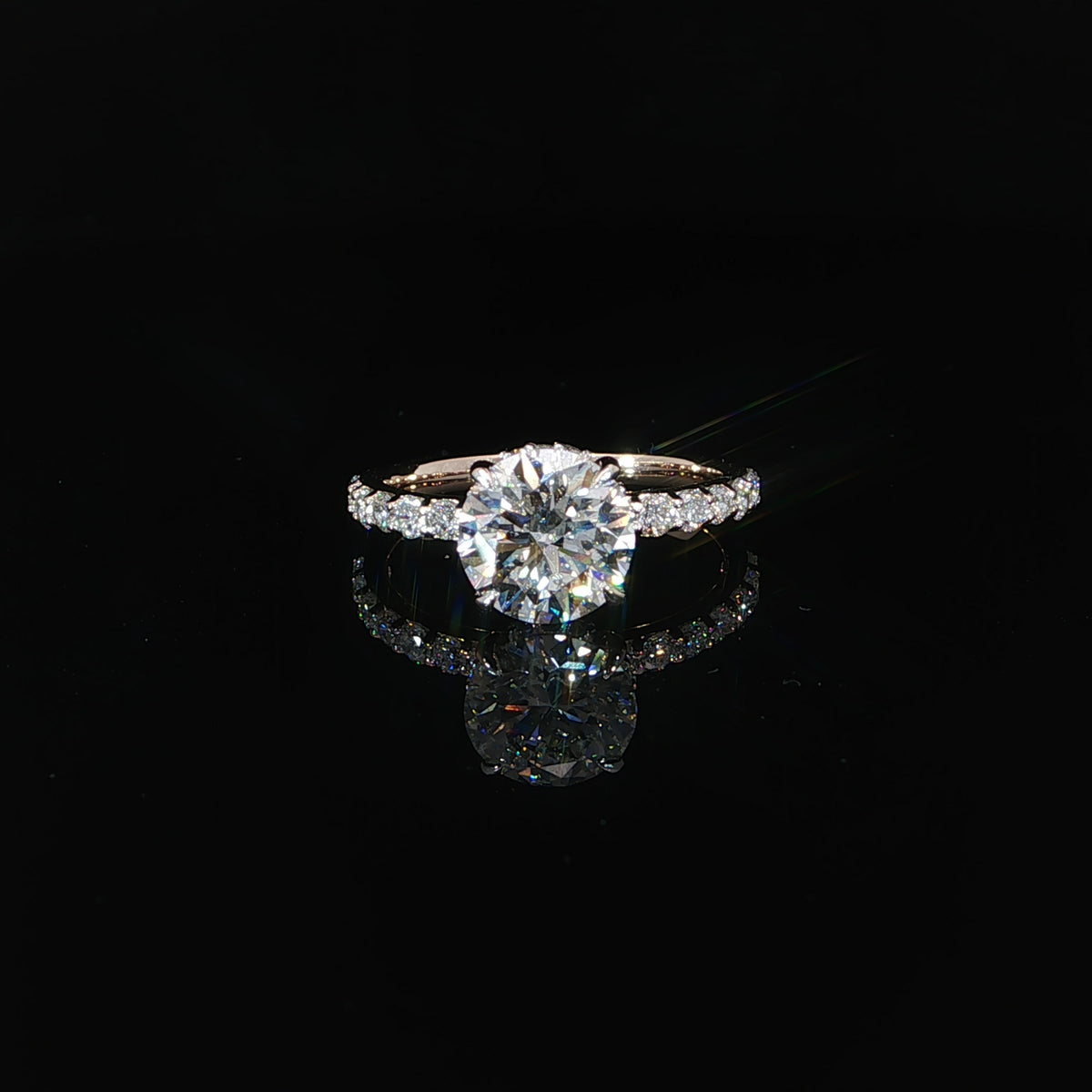 Front view of a 2.10ct round diamond engagement ring featuring a hidden halo and rose gold diamond band.