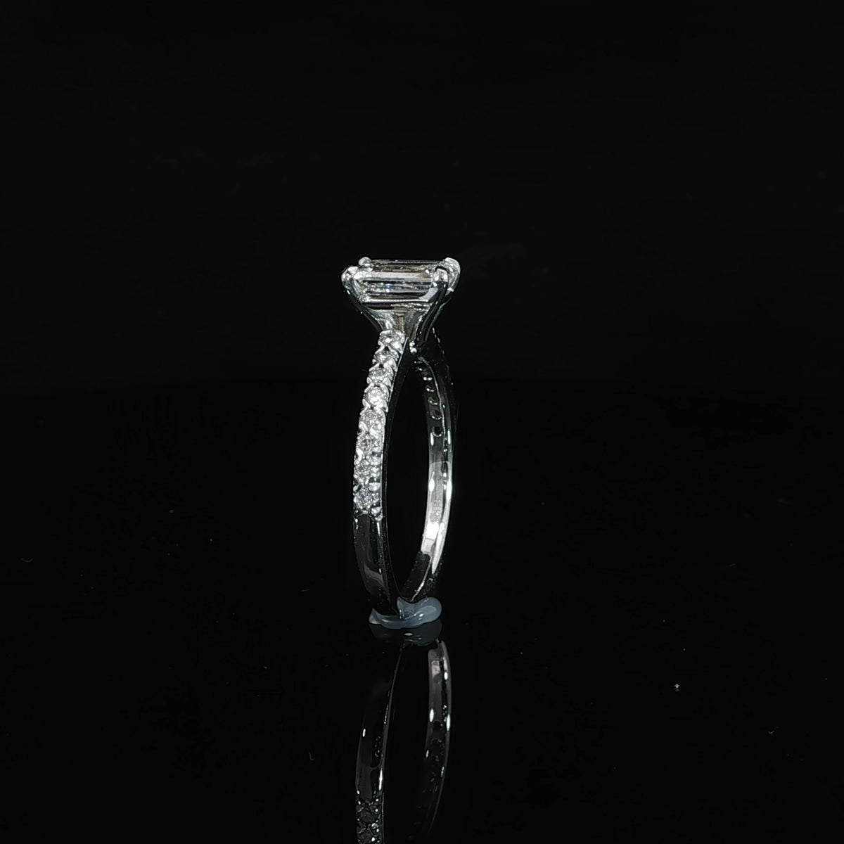 Side profile of a 14K white gold emerald-cut engagement ring with 1.30 CTW of diamonds.
