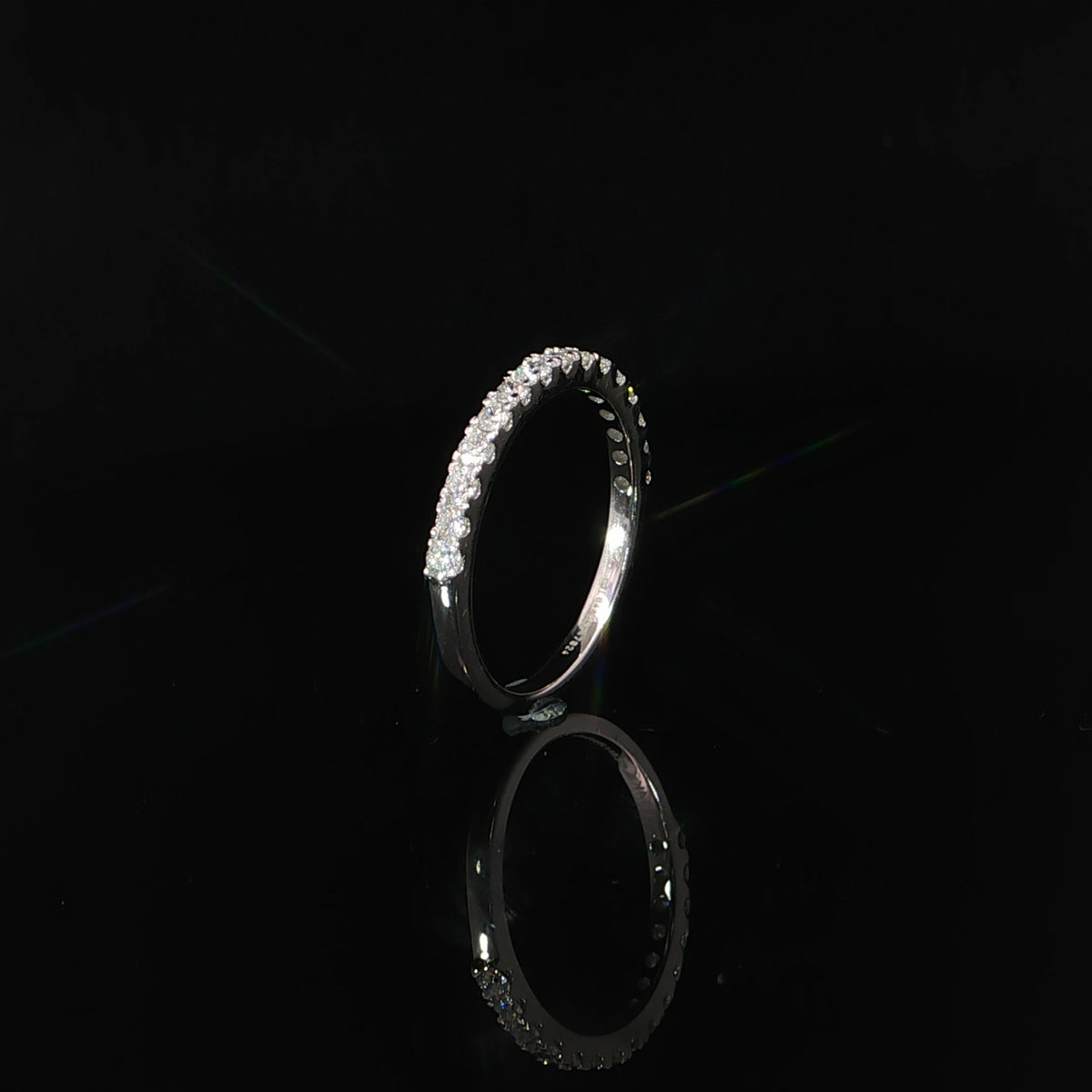 Upright side profile of a 14K white gold diamond band with a smooth lower shank.
