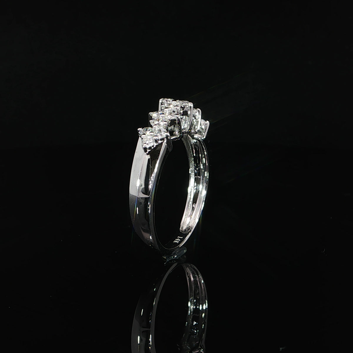Side profile of a white gold diamond cluster ring with an open gallery and smooth polished band.