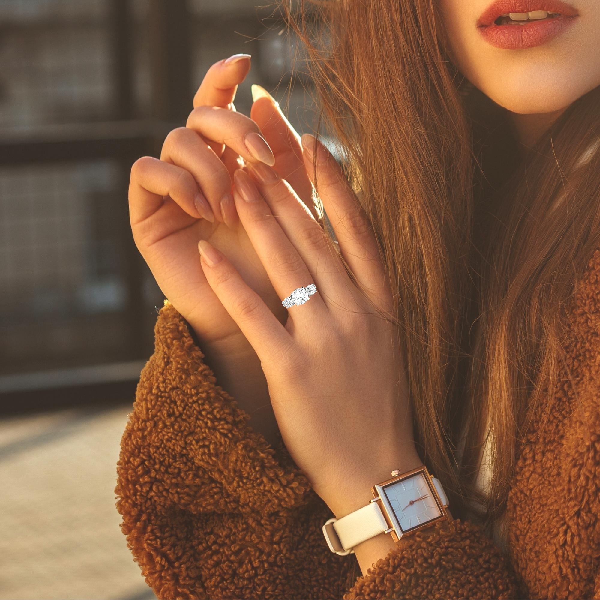 Model wearing elegant three-stone engagement ring with round diamonds in 14K white gold