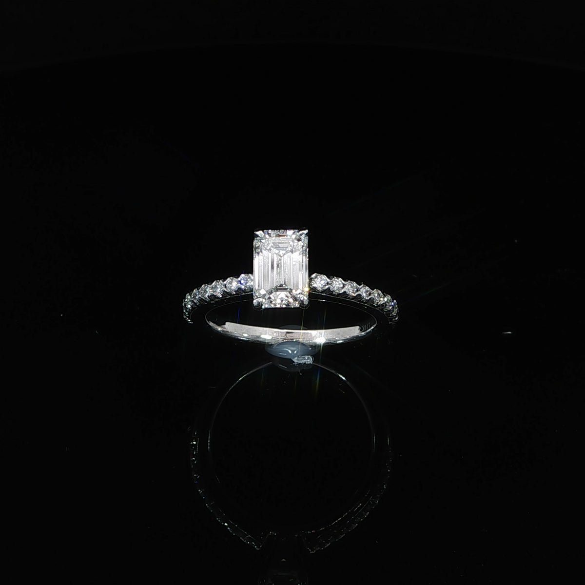 Front angle showing a 1.13-carat emerald-cut diamond between diamond-set shoulders in 14K white gold.