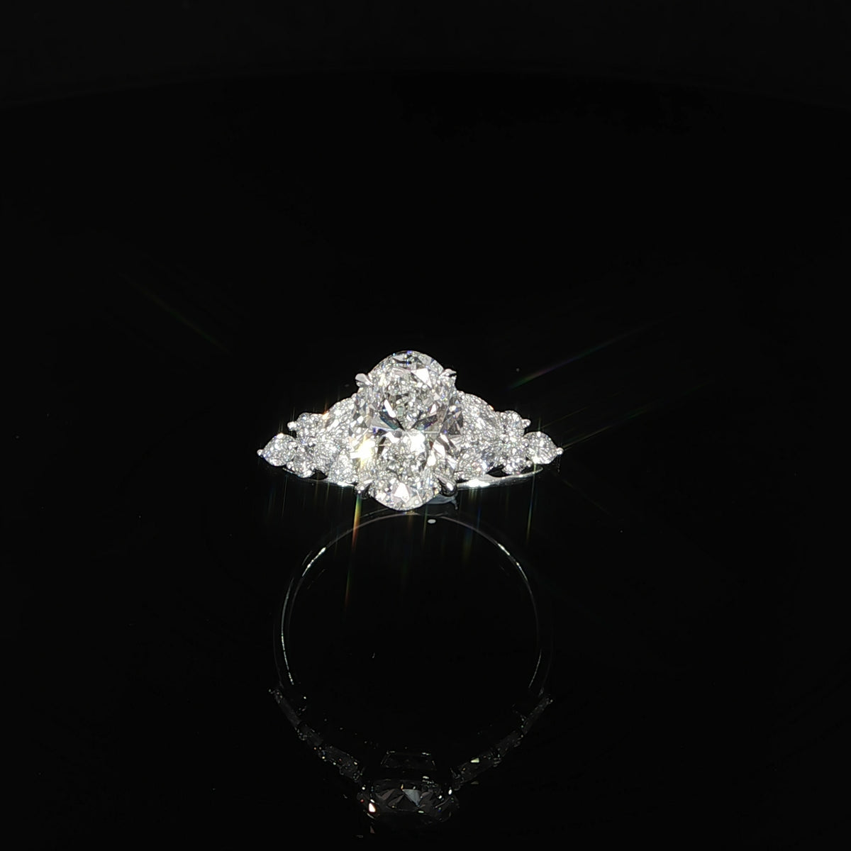 Front view of a 2 carat oval lab grown diamond engagement ring in 14K white gold with round and marquise side diamonds.