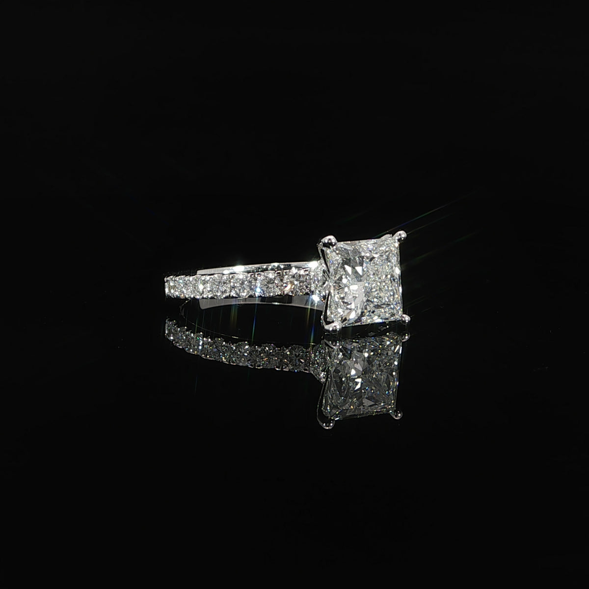 Princess cut engagement ring with sparkling pave-set diamond band in polished 14K white gold.