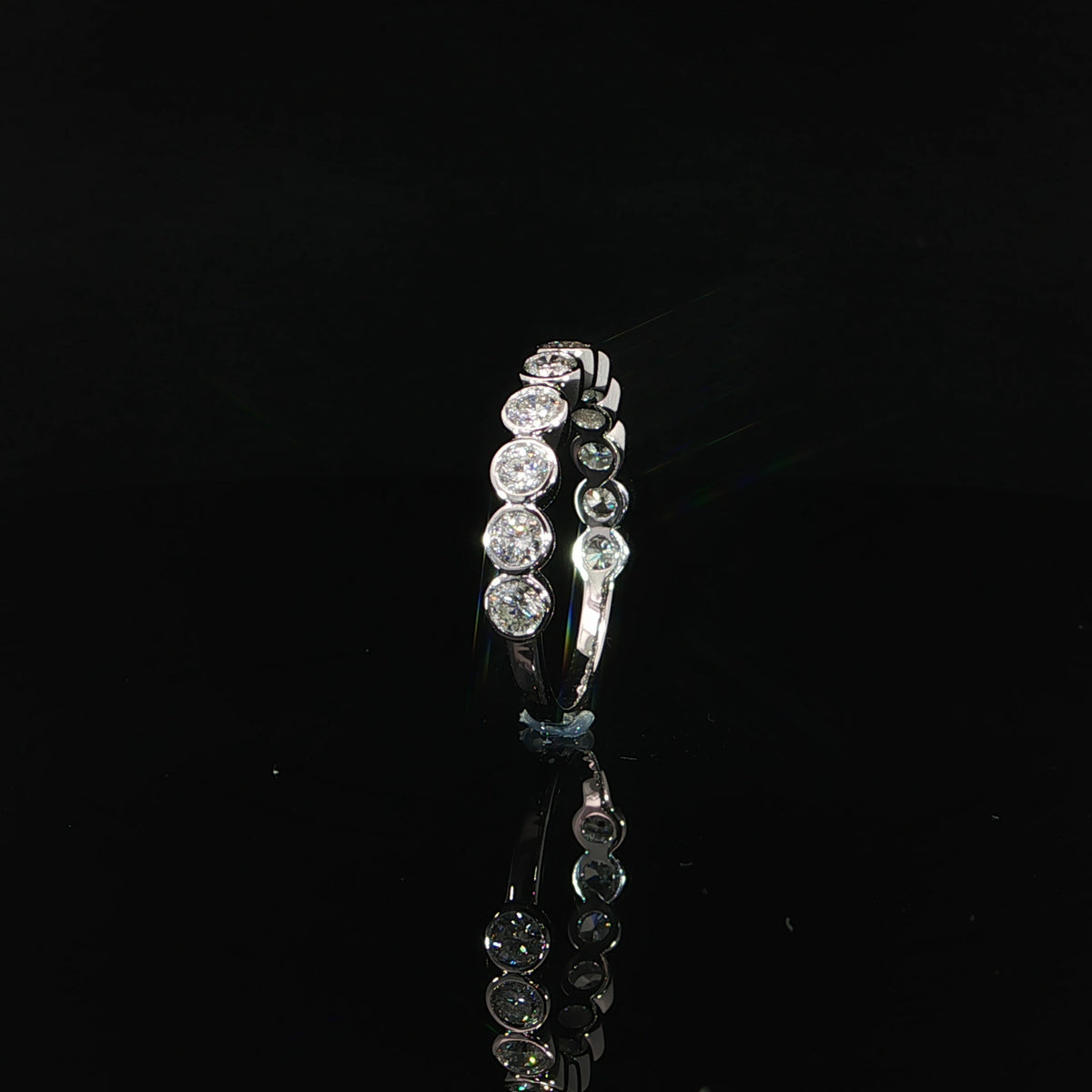Side view revealing circular openings beneath the diamonds and polished white gold bezel walls.