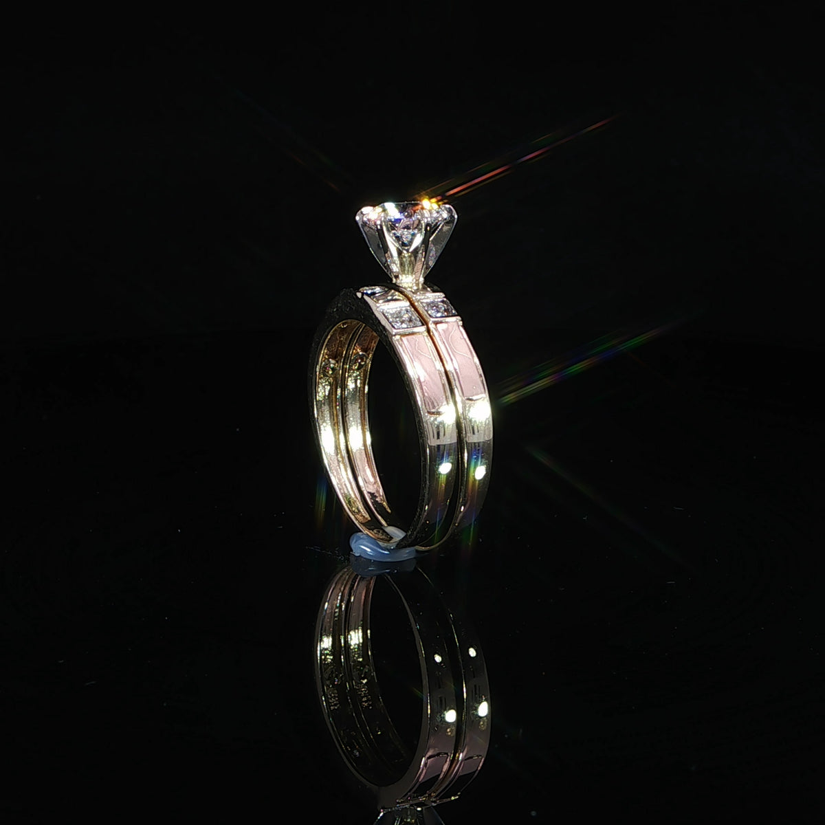Upright side view of a 14K yellow gold bridal set showing the elevated diamond setting and parallel bands.