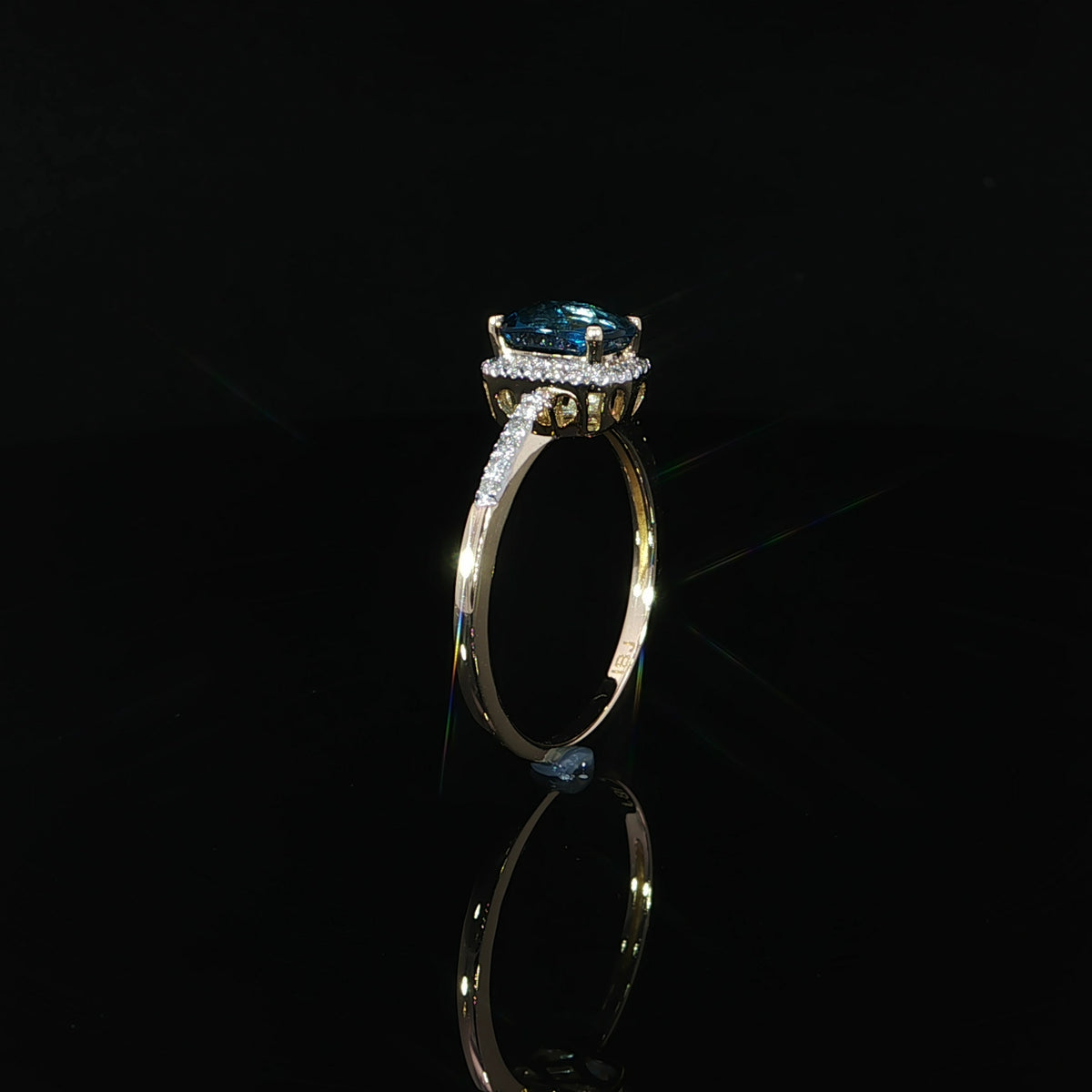 Upright profile of a 7 × 5 mm natural blue topaz ring in 14K yellow gold with 0.09 CTW diamonds.
