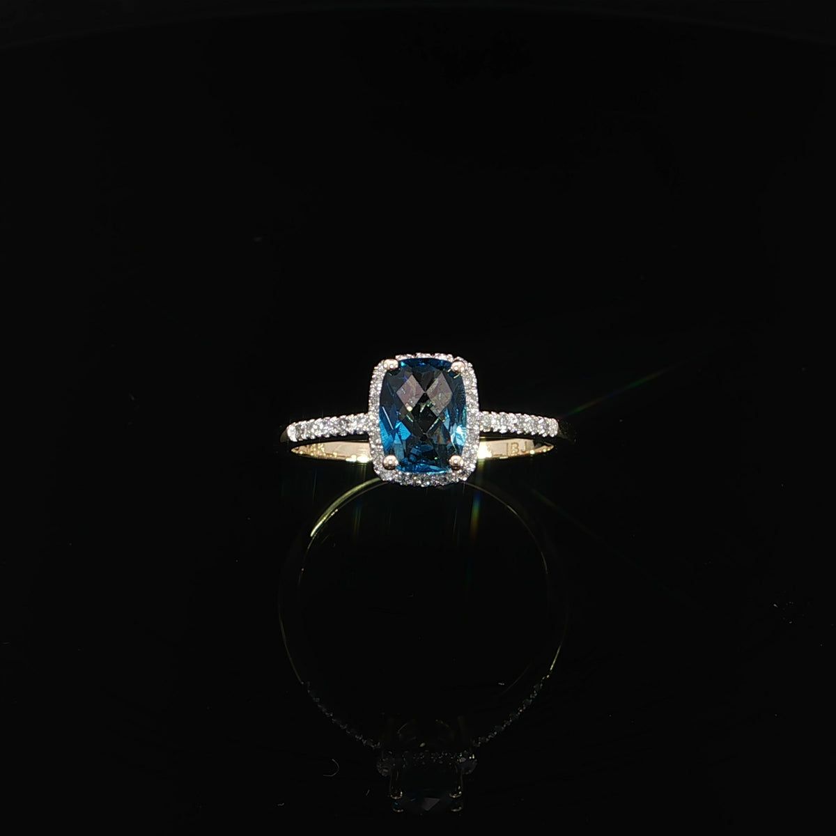 Upright front view of a 14K yellow gold cushion-cut blue topaz ring with 0.09 CTW diamonds.