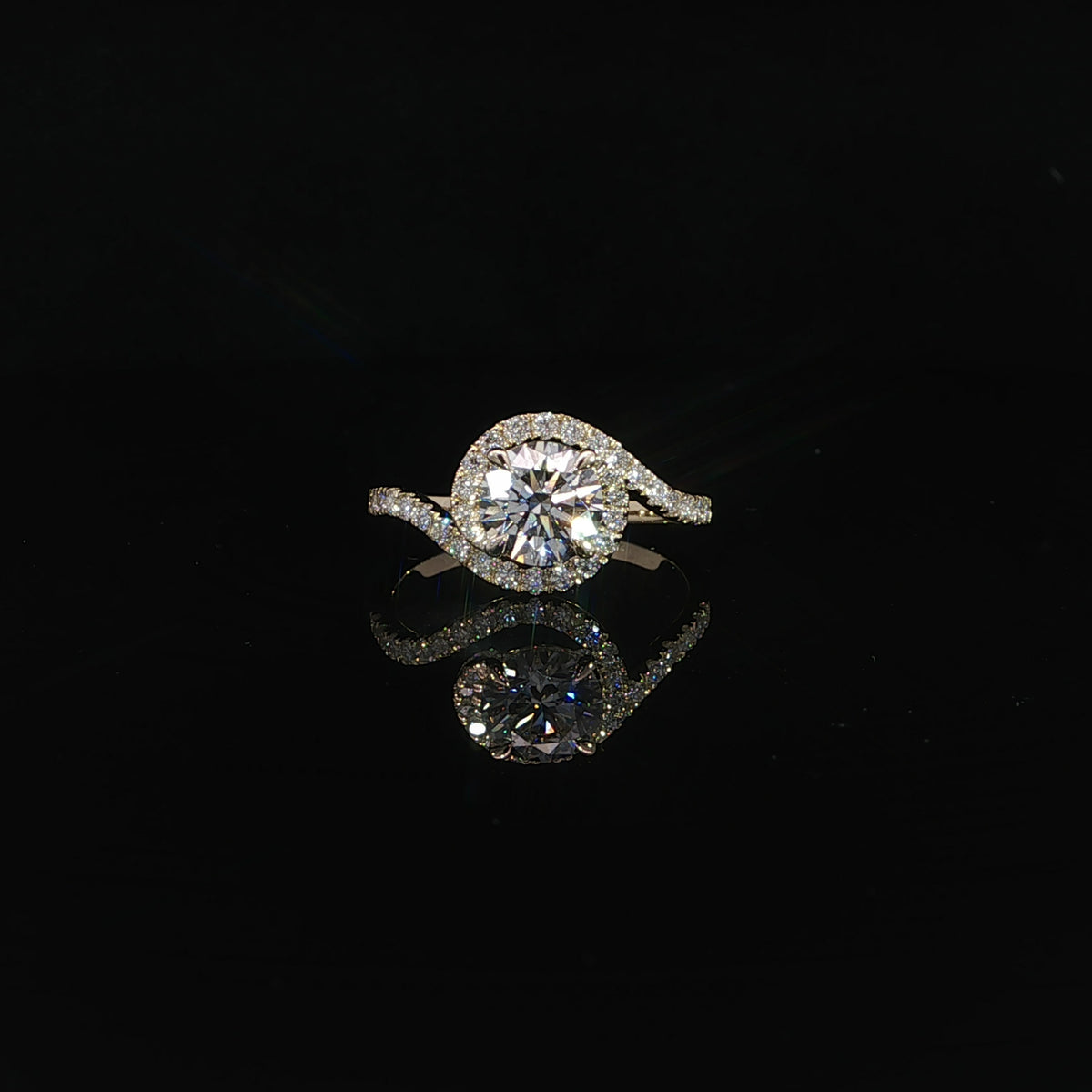 Close-up of pavé diamond detailing on flowing 14K yellow gold bypass band