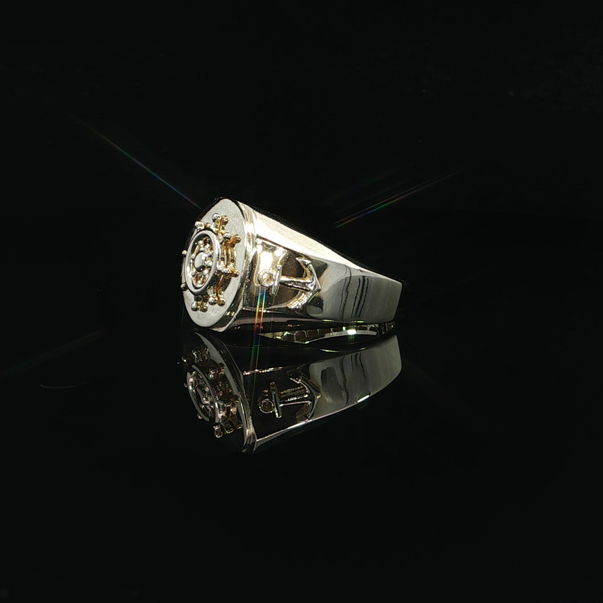 Angled view of a 14K yellow gold signet ring with a raised mariner wheel and anchor shoulder detail.