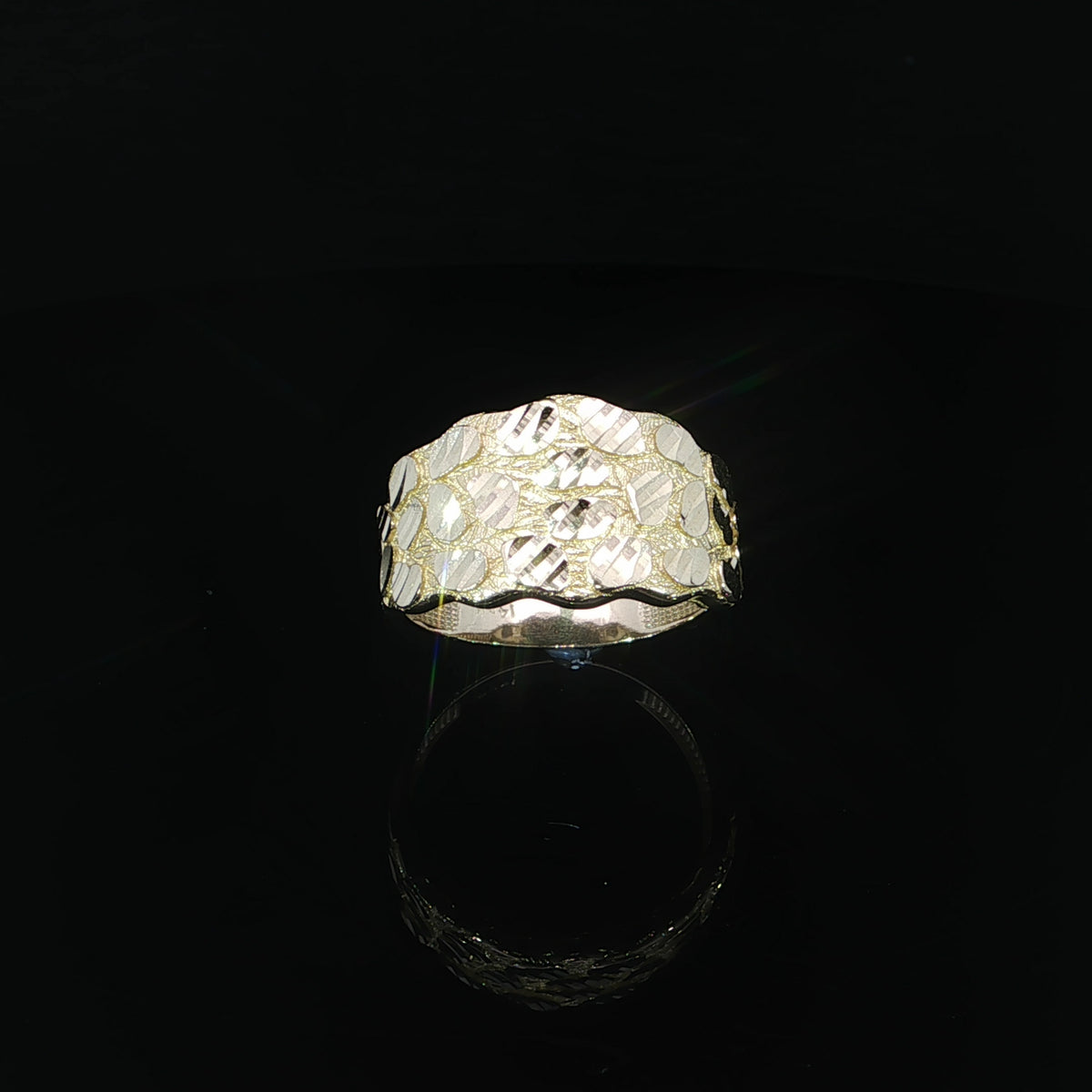 Elevated front view of a 14K yellow gold nugget ring showcasing its wide textured surface, reflective faceted accents, and softly scalloped edges.