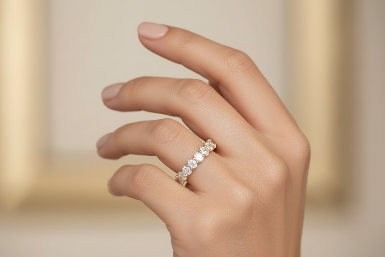 14K yellow gold half eternity oval band worn on model hand