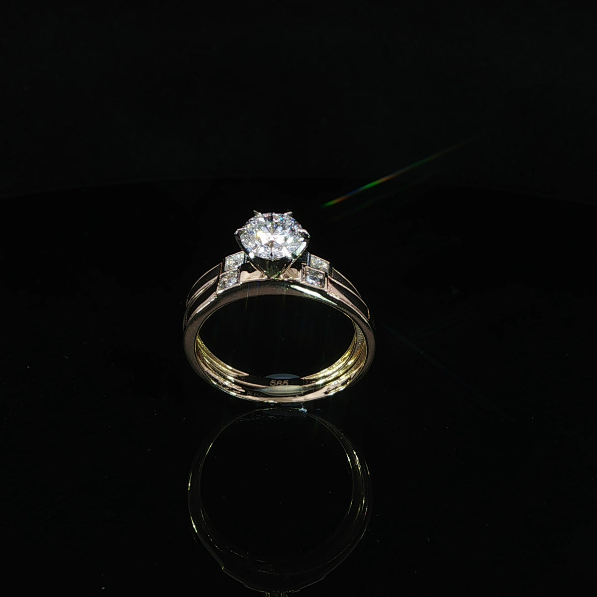 14K yellow gold wedding set viewed at an angle, showing the round center diamond and both band interiors.