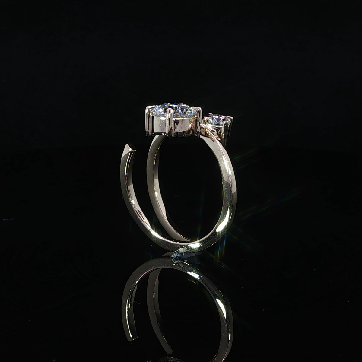 Side profile of a yellow gold two-stone diamond ring showing raised settings and an open curved band.